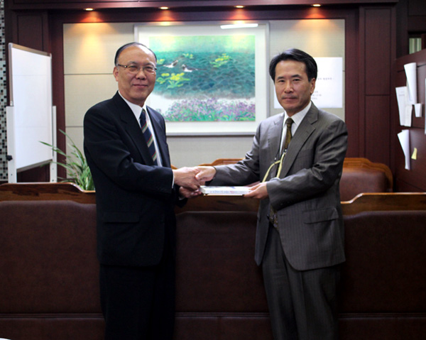 이돈희 본지 수석부사장 겸 수석논설위원(왼쪽)이 김정일 선린인터넷고등학교장(오른쪽)에게 도서를 기증하고 있다.